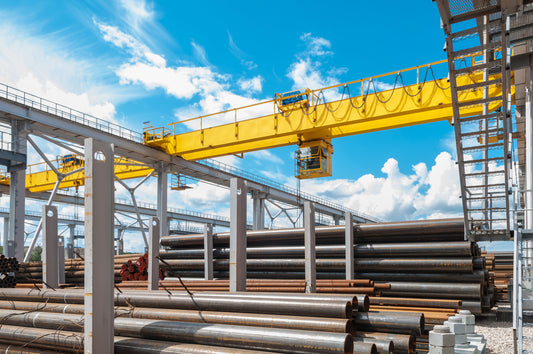 Gantry crane training with yellow crane and metal pipes