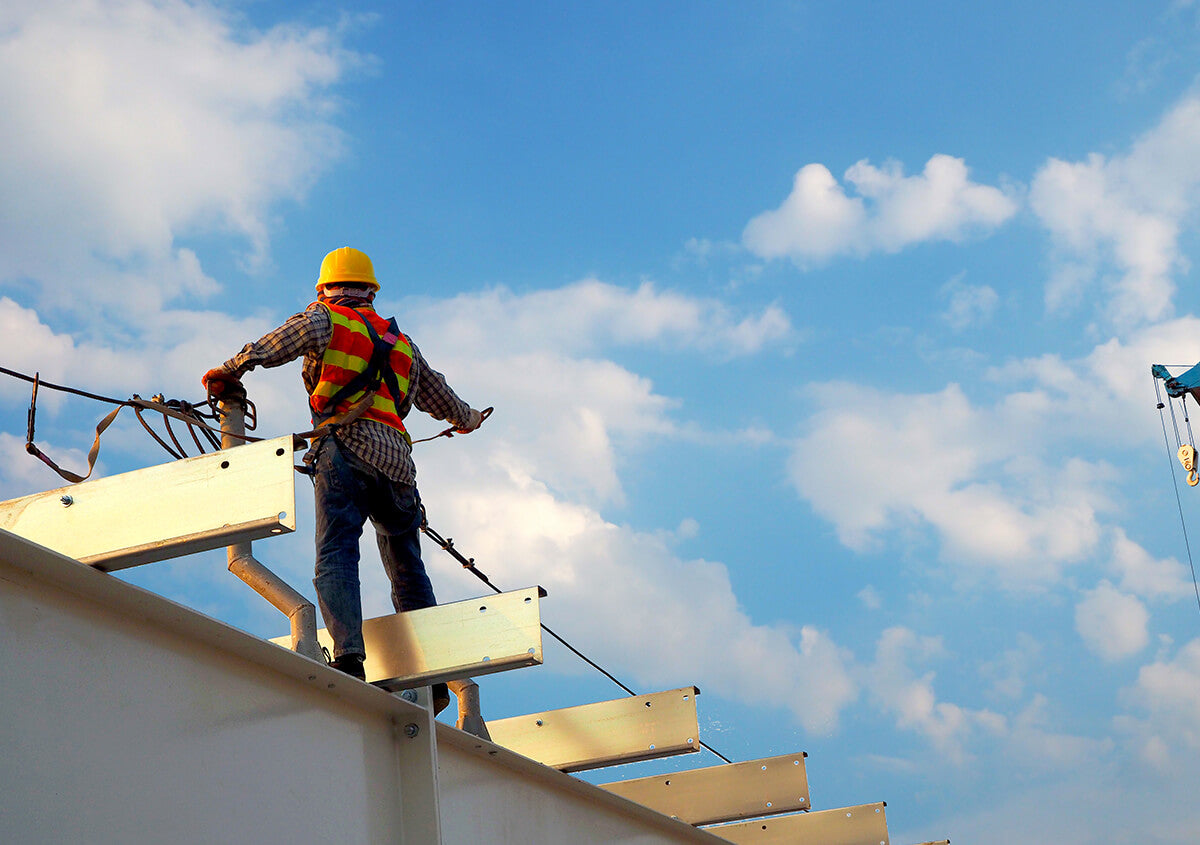 Worker at height wearing safety harness.