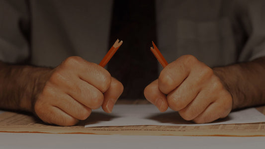 Frustrated person breaking a pencil.
