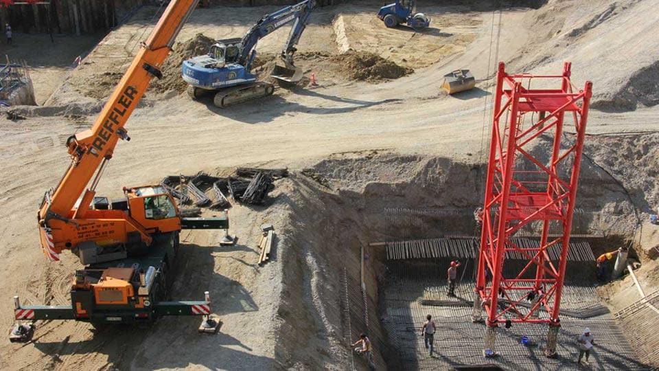 Excavation site with cranes and workers, from Hazard Guide