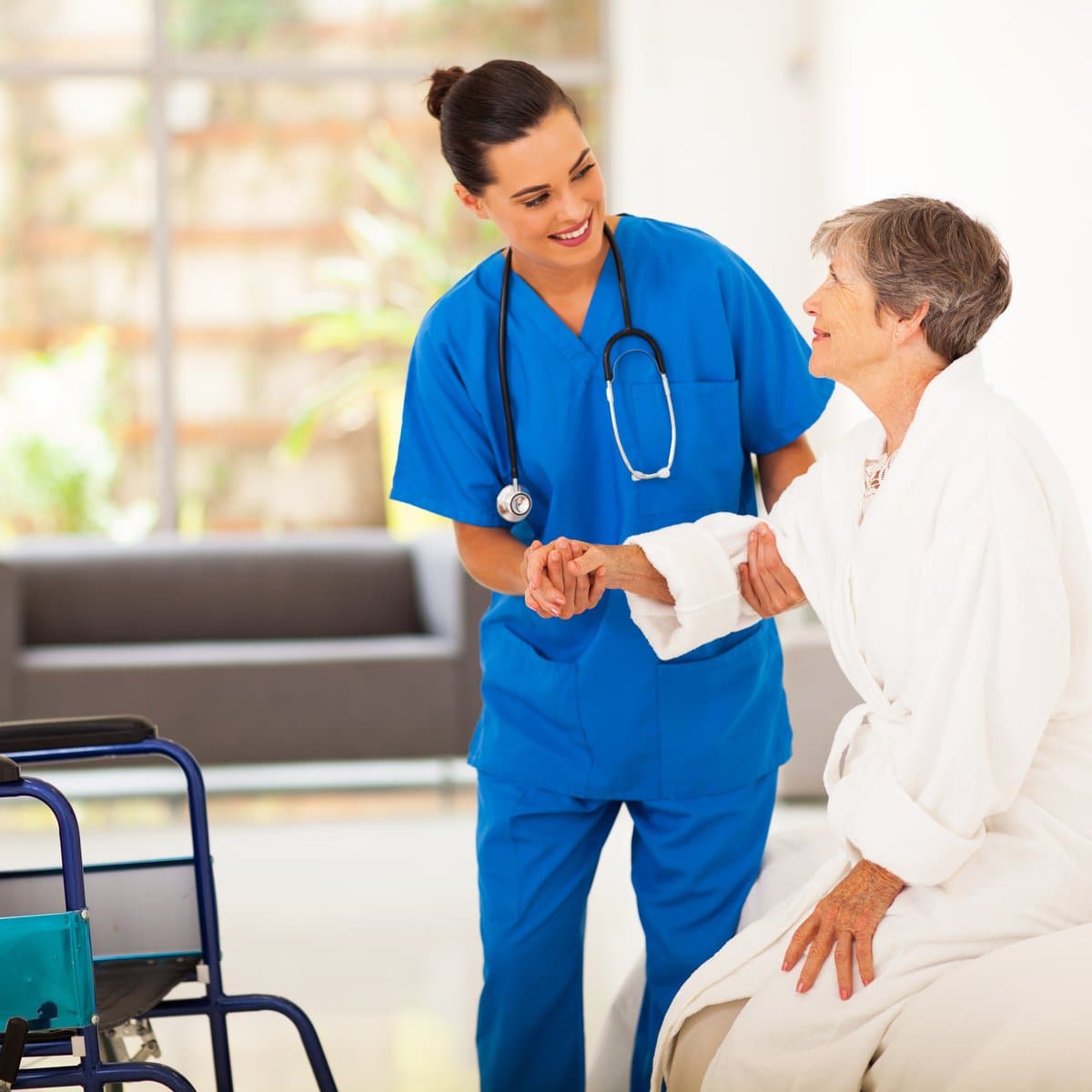 Nurse assisting elderly patient, manual handling in healthcare