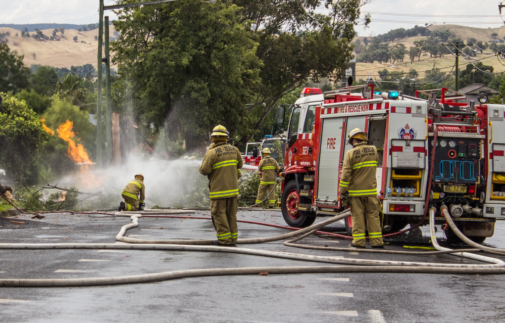 Firefighters battling a blaze with fire trucks and hoses.